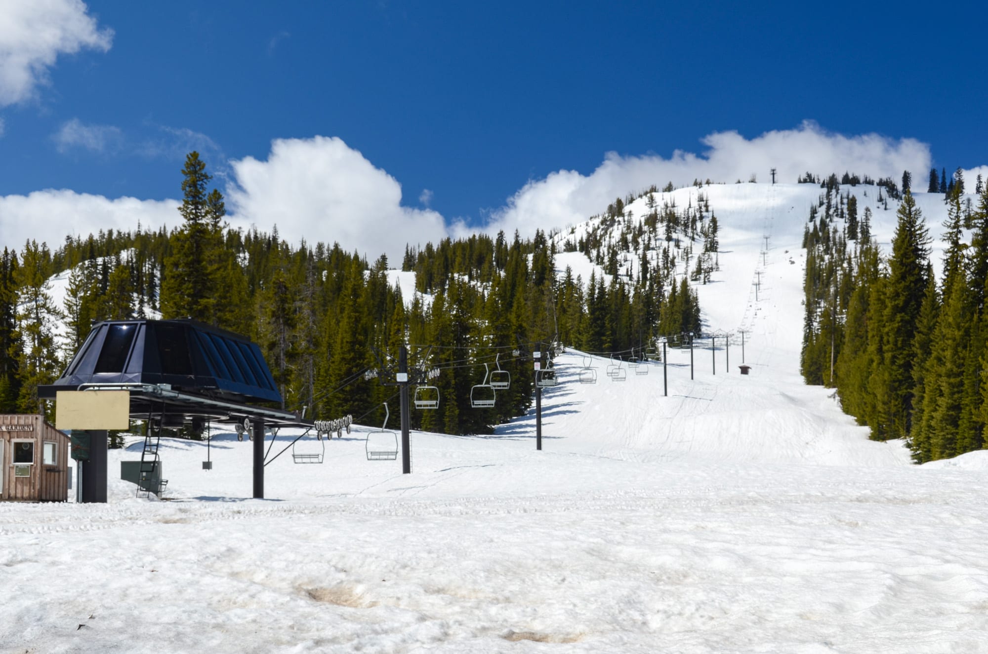 Chairlift base terminal and a snow-covered run lined with conifers at Anthony Lakes ski area