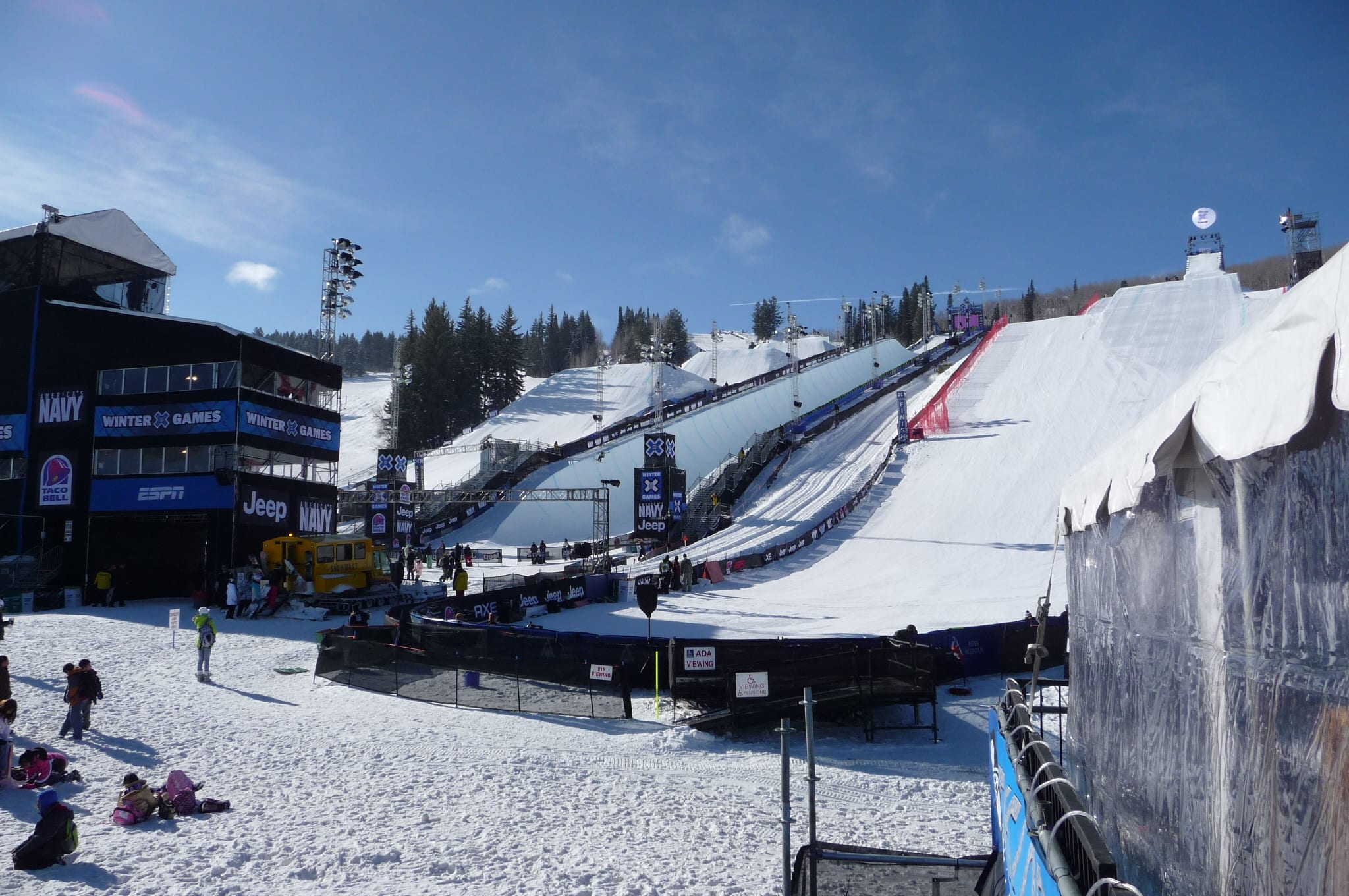 X Games venue at Buttermilk with superpipe, slopestyle course, scaffolding and broadcast structures on snowy slope