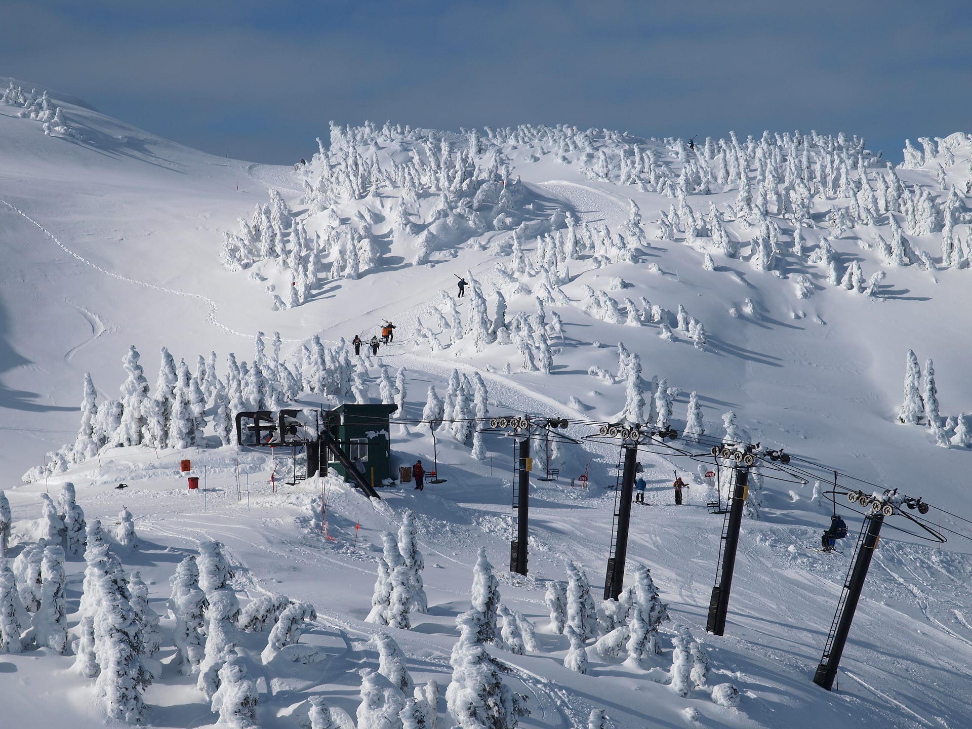Snow-covered upper slopes and rime-coated trees above the top terminal of a chairlift at Eaglecrest, Alaska
