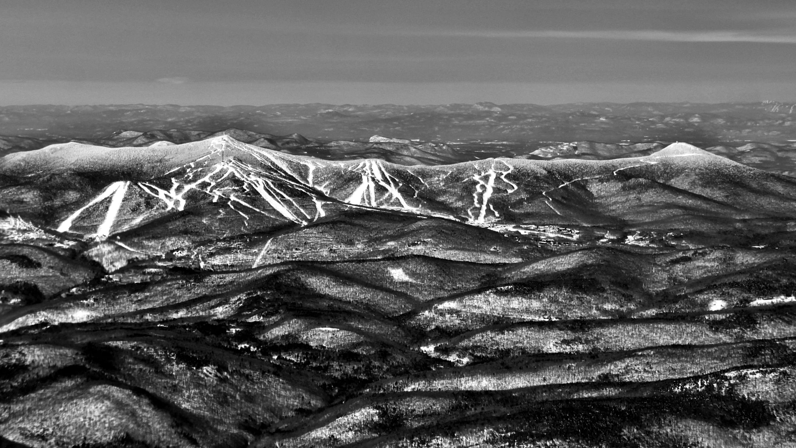 Aerial black-and-white view of Killington's snow-covered trail network spread across forested Vermont ridges