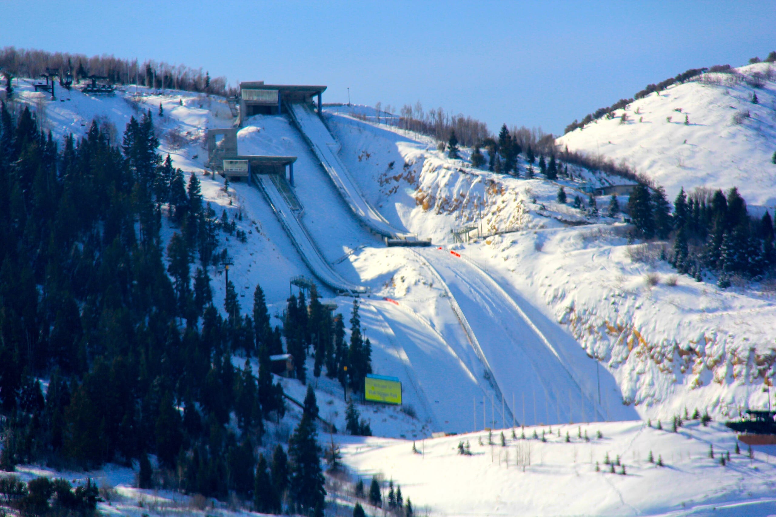 Snow-covered ski jump hills with inrun towers and landing slopes at Utah Olympic Park in winter